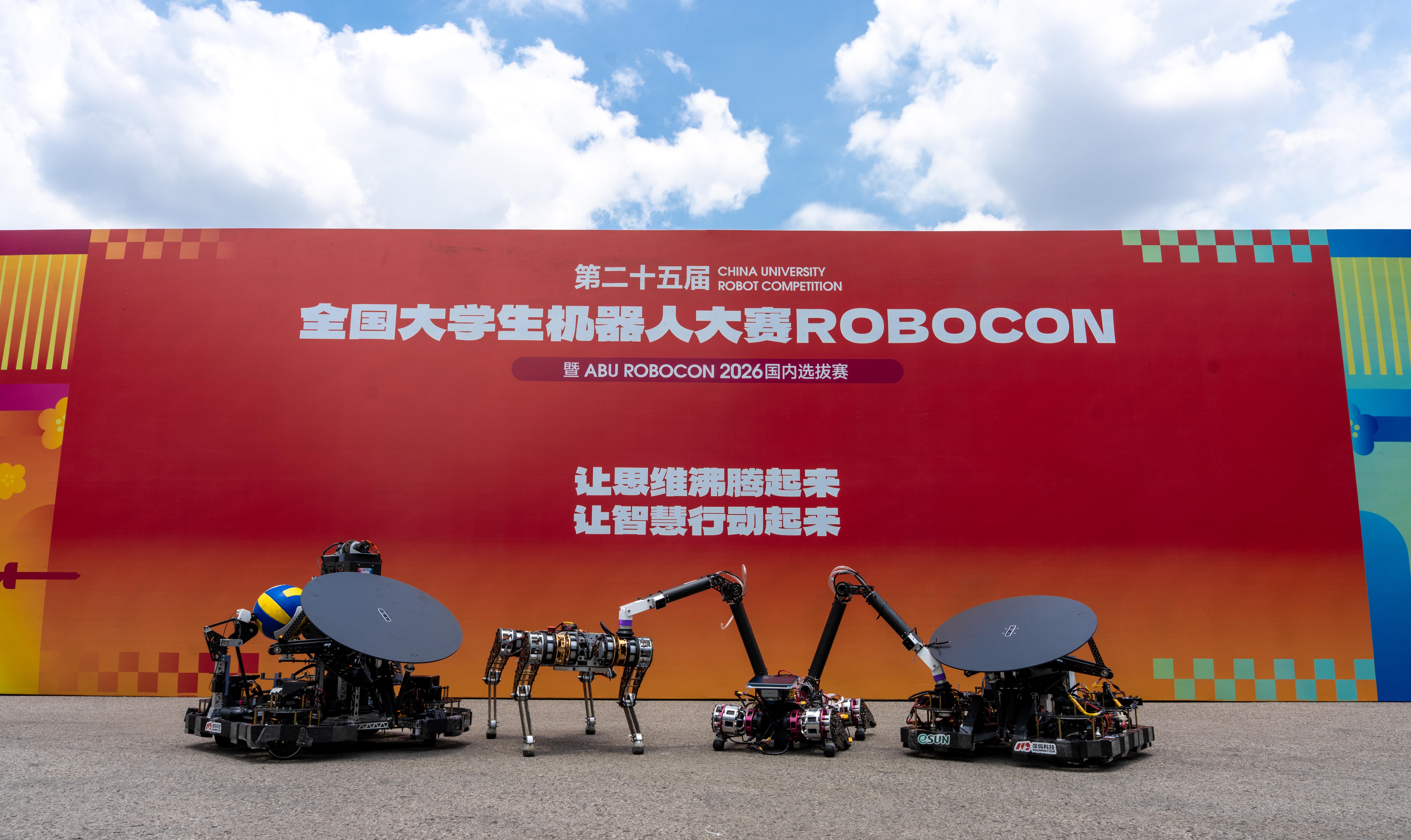 两台排球车与两台四足机器人在展板前合影